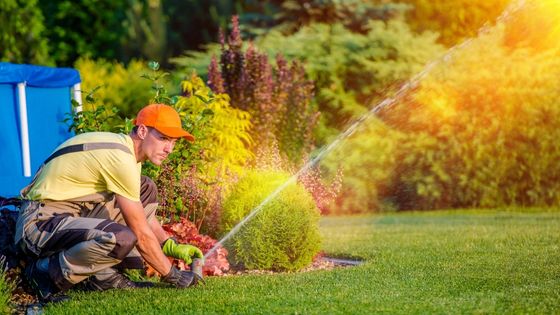 man fixing garden sprinkler - greywater system